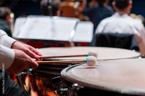 The hands of a musician playing on a timpani