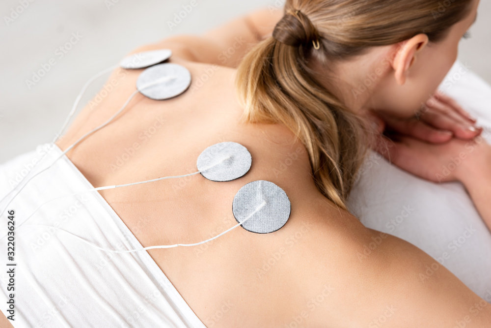 Ταπετσαρία High angle view of young woman with electrodes on back during electrode treatmen