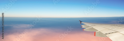 Airplane wing and sky with copy space, panoramic web banner, travel concept