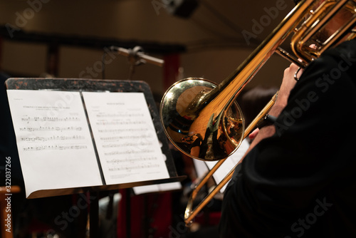 Trombone in the hands of musicians in the orchestra