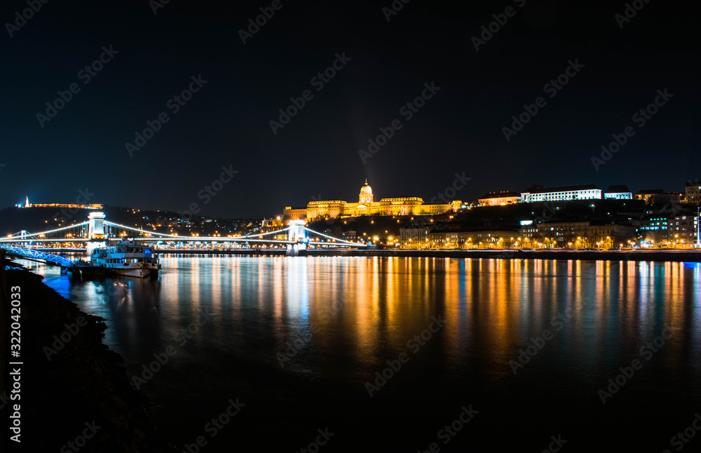 Paisaje nocturno del río Danubio con el castillo de Buda detrás