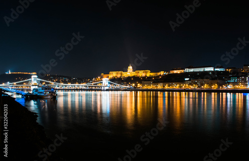 Paisaje nocturno del río Danubio con el castillo de Buda detrás