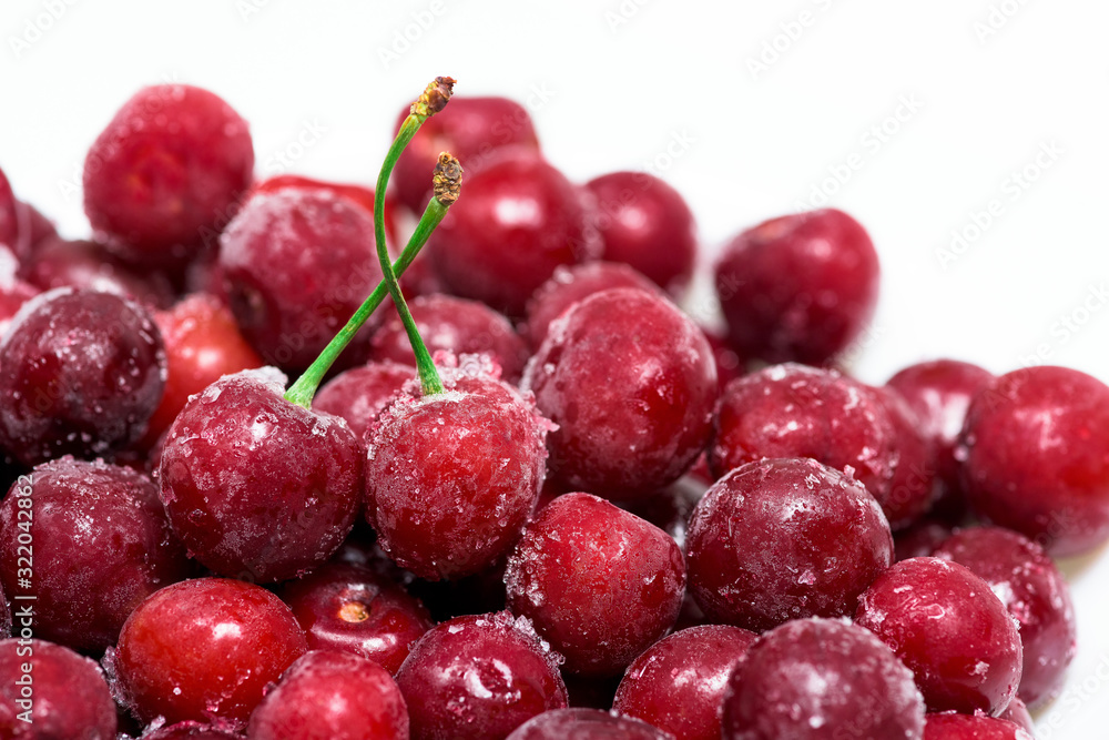 group of frozen cherries on a white background in a white plate. . close up. ice crystals on the fruit. vertical photo of the top view . macro group of frozen cherries on a white background in a white plate. . close up. ice crystals on the fruit. vertical photo of the top view . macro