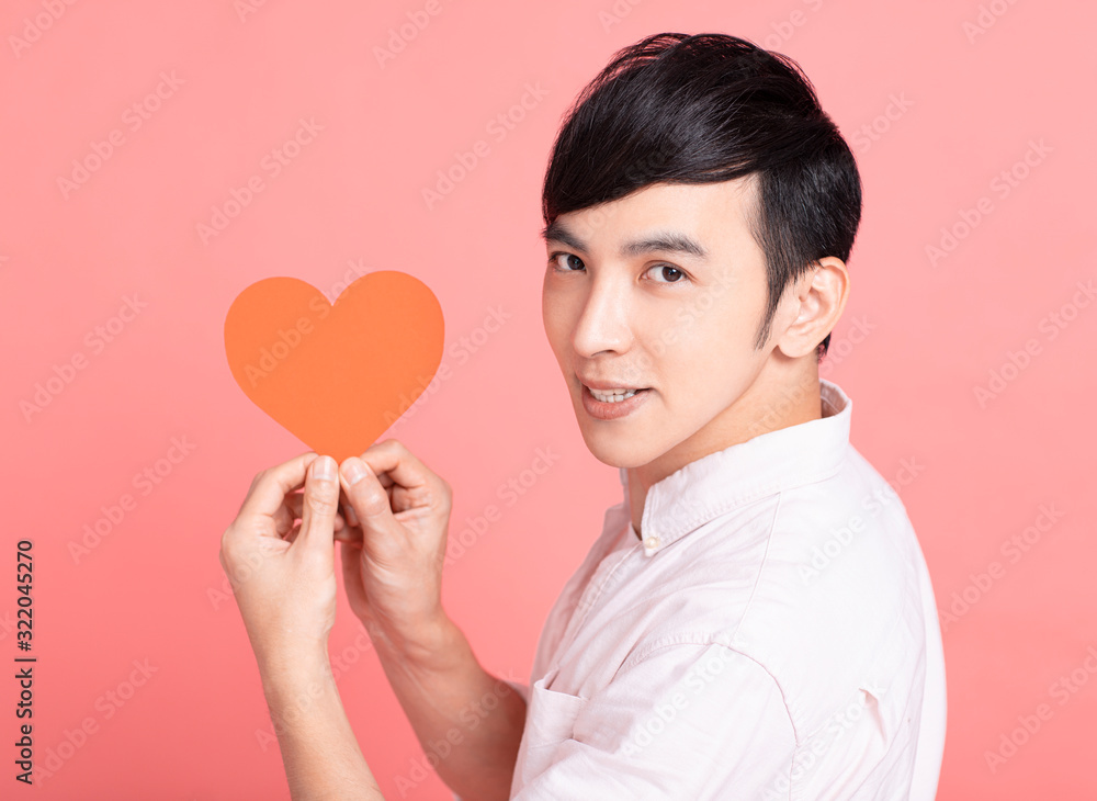 Happy young man showing red paper hearts and celebrating valentines day Happy young man showing red paper hearts and celebrating valentines day