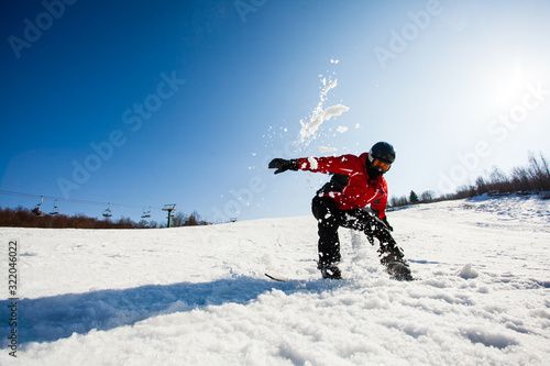 Man on a snowboard falling down on snow