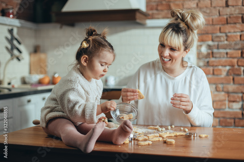 Mother and daughter baking cookies in their kitchen