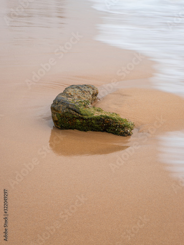 One rock on the wet sand.