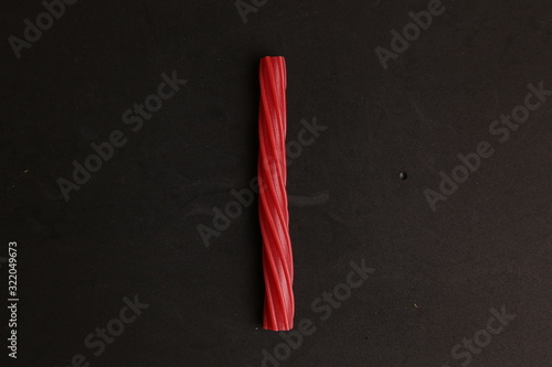 sweet red gummy licorice in color background photo