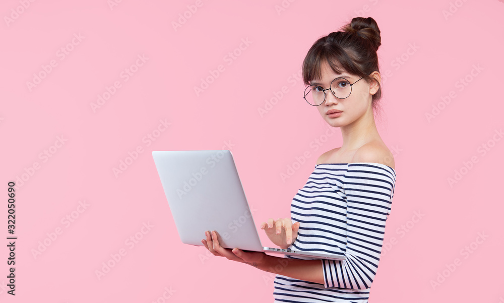 Shocked worried young asian female office assistant in eyeglasses hold laptop, stand pink background Shocked worried young asian female office assistant in eyeglasses hold laptop, stand pink background