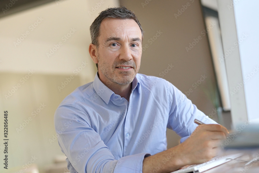 Portrait of businessman in office looking at camera