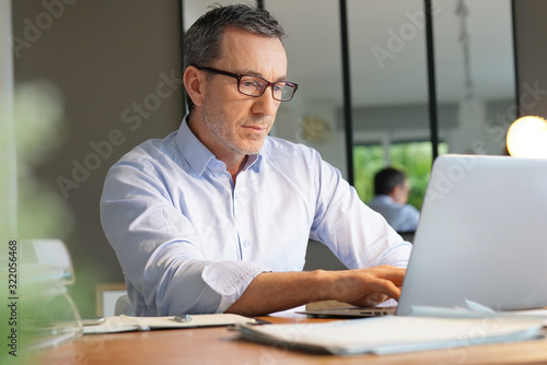Business manager working in office on laptop photo