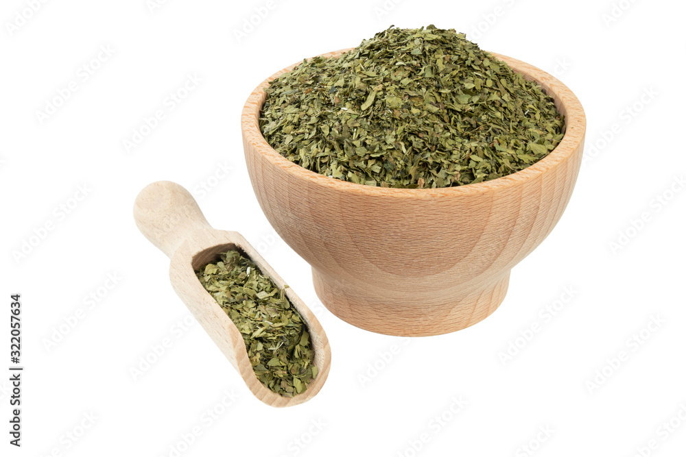 dried lovage herb in wooden bowl and scoop isolated on white background. front view. spices and food ingredients dried lovage herb in wooden bowl and scoop isolated on white background. front view. spices and food ingredients