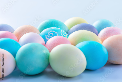 Colorful Easter eggs dyed by colored water isolated on a pale blue background  design concept of Easter holiday activity  close up  copy space.