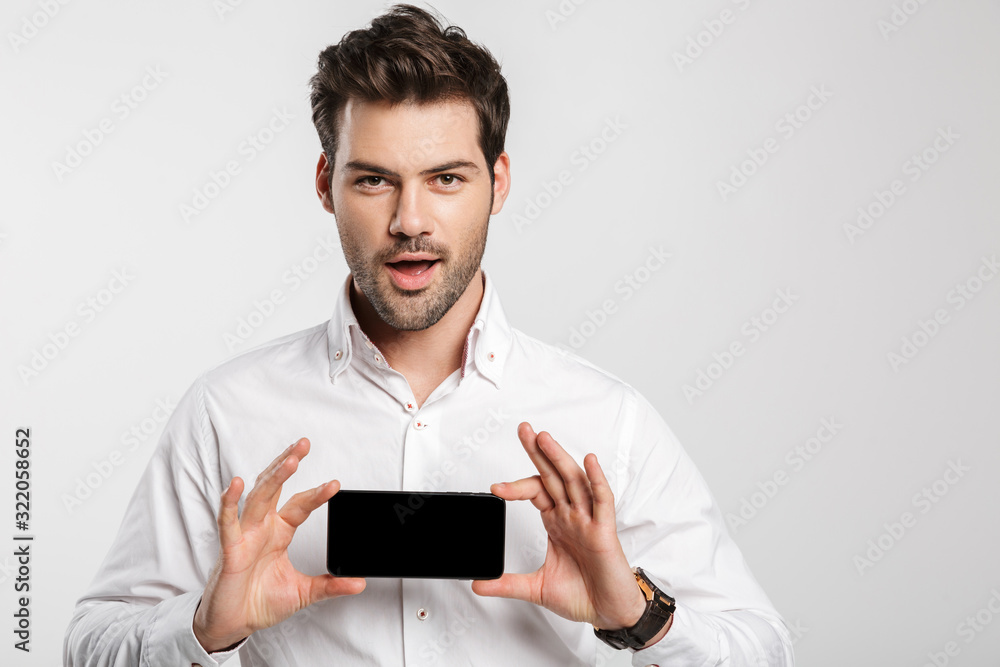 Handsome young businessman showing display of mobile phone. Handsome young businessman showing display of mobile phone.