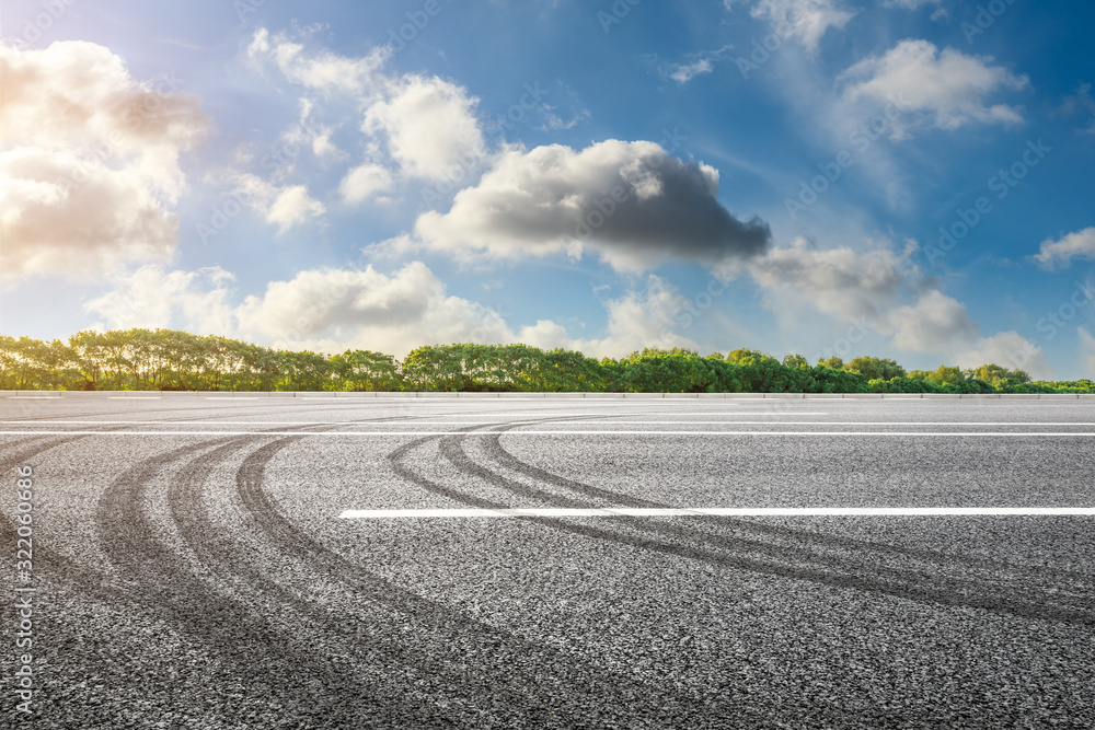 Fototapeta premium Asphalt road and green woods background