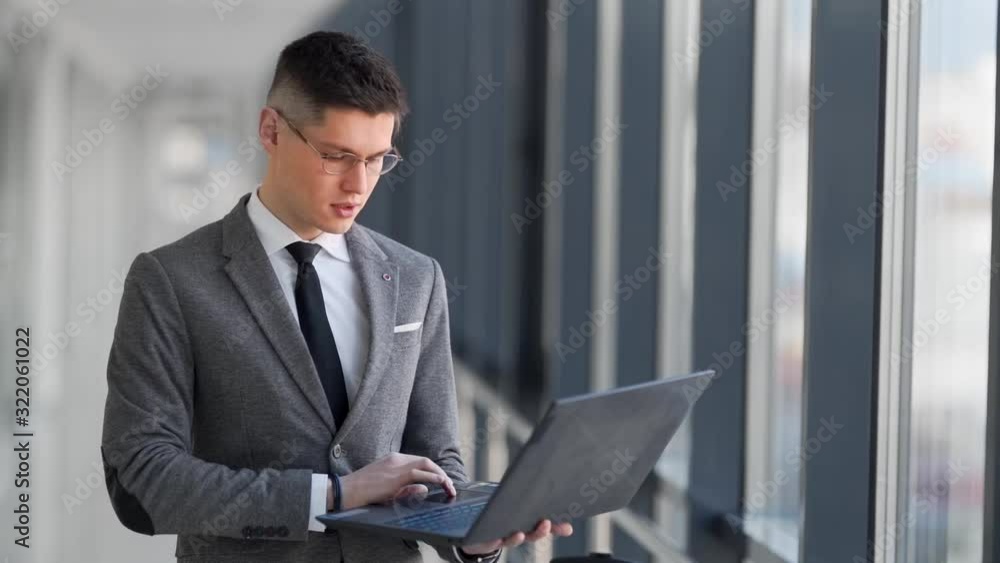 closeup, young businessman in glasses looking at laptop closeup, young businessman in glasses looking at laptop