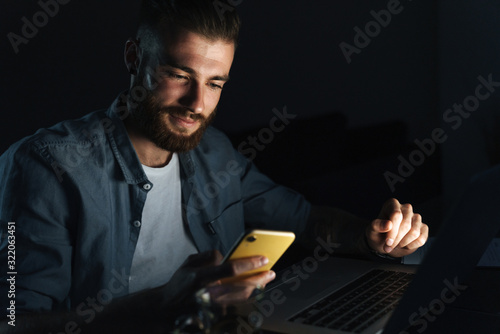 Confident young man working on laptop computer