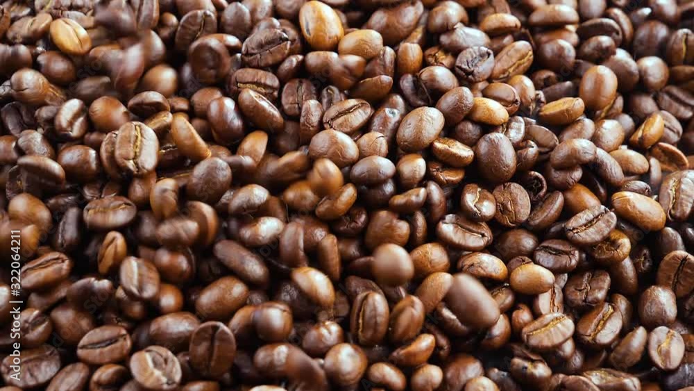 Coffee beans are fried in a pan and mixed with a spoon Coffee beans are fried in a pan and mixed with a spoon