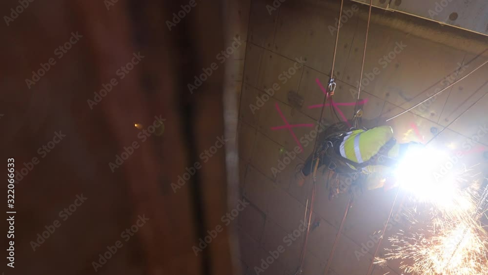 Footage rope access high risk wearing full safety harness, helmet, mask ...