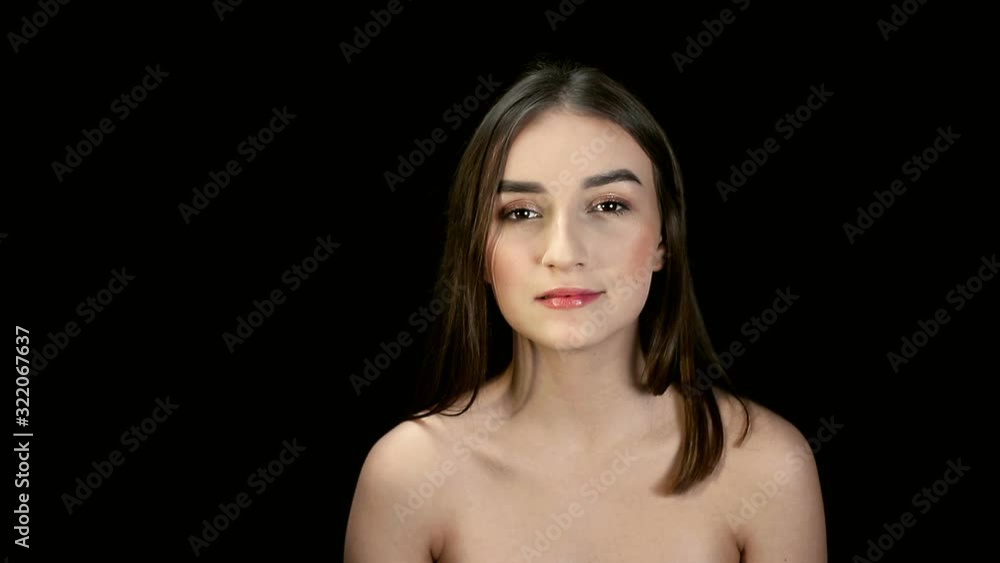 Fashion girl with black hair, brunette turns her head and swings her hair and effectively looks at the camera. Model posing on a black background Fashion girl with black hair, brunette turns her head and swings her hair and effectively looks at the camera. Model posing on a black background