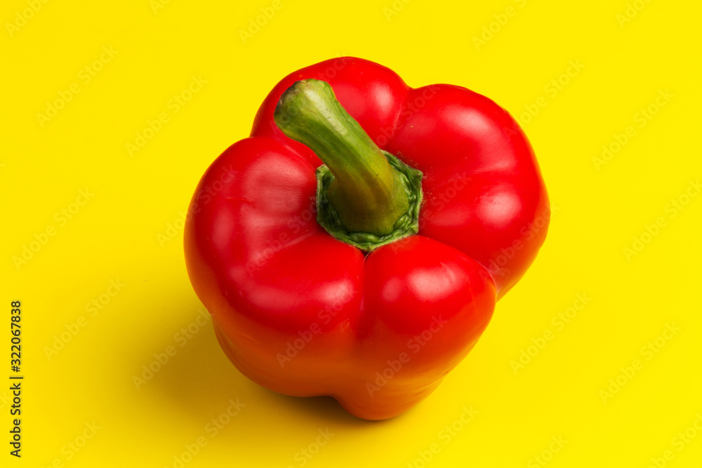 one red bell pepper on yellow background. close up one red bell pepper on yellow background. close up