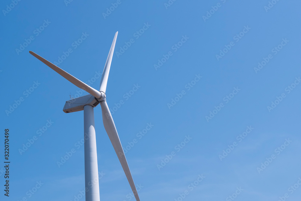 Wind turbine spinning for electricity production with blue sky Wind turbine spinning for electricity production with blue sky