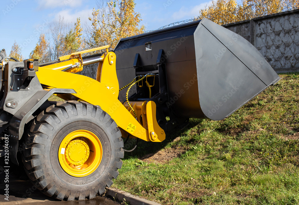 large bucket for loading wood chips mounted on a front-end loader, industry, unloading large bucket for loading wood chips mounted on a front-end loader, industry, unloading