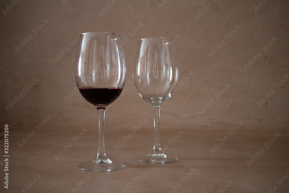 2 wine glasses, one empty, one full 2 wine glasses, one empty, one full