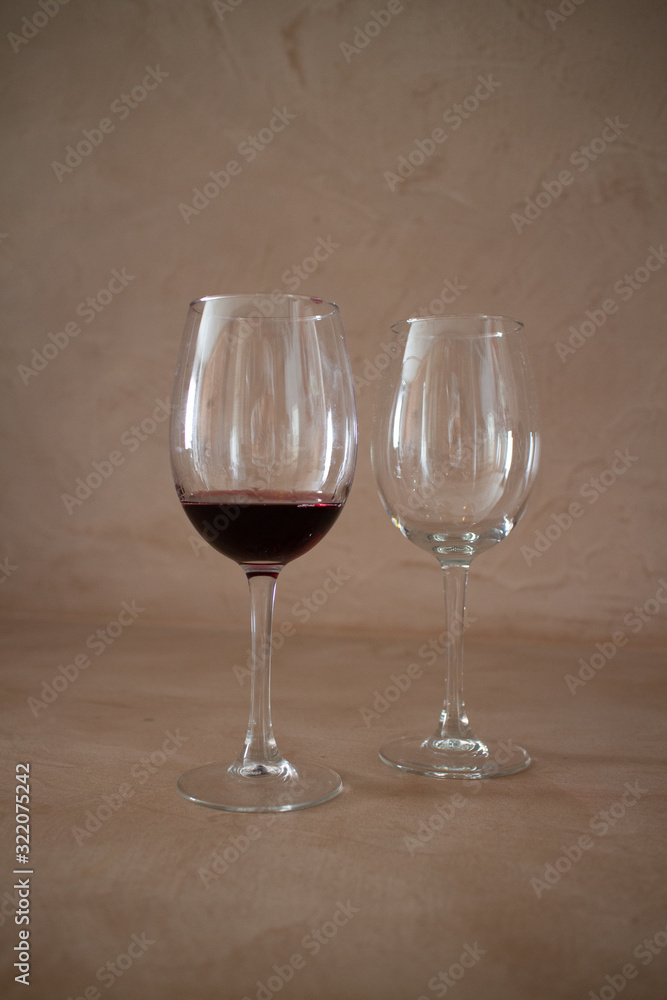 2 wine glasses, one empty, one full