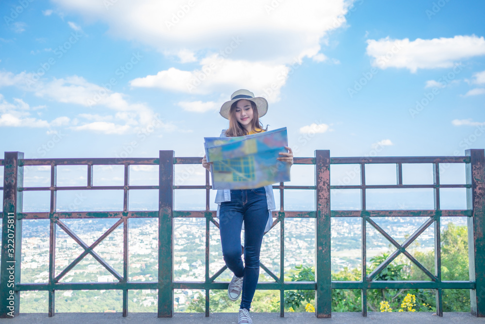 Smiling woman traveler in doi suthep temple chiangmai landmark in thailand holding world map with backpack on holiday, relaxation concept, travel concept