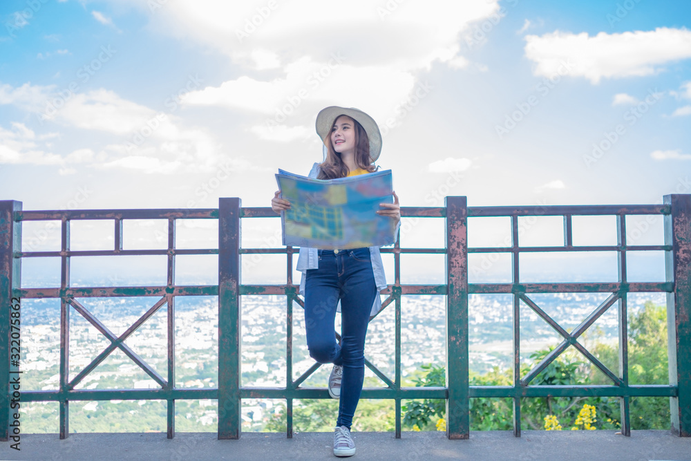Smiling woman traveler in doi suthep temple chiangmai landmark in thailand holding world map with backpack on holiday, relaxation concept, travel concept