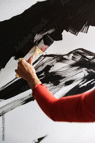 Portrait of young woman using painting tools while drawing in studio