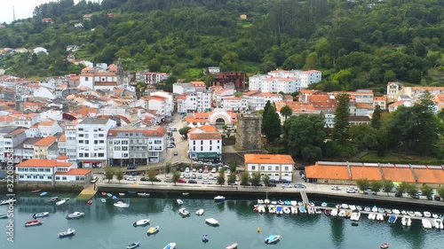 Aerial view of Pontedeume village houses and small fishing boats in northwestern Spain.