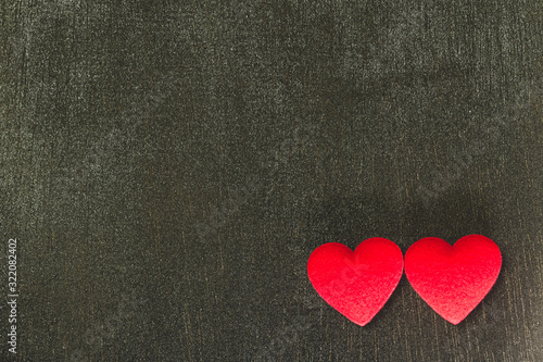 Two red hearts on black wooden background darktone, copy space, Valentine's Day concept.