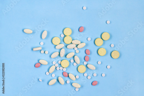 Pharmaceutical medicine pills  tablets on blue background. Health care. Top view.