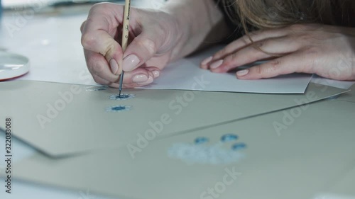 Young woman, a jewelry designer is drawing a sketch for a new ring at a jewelry production