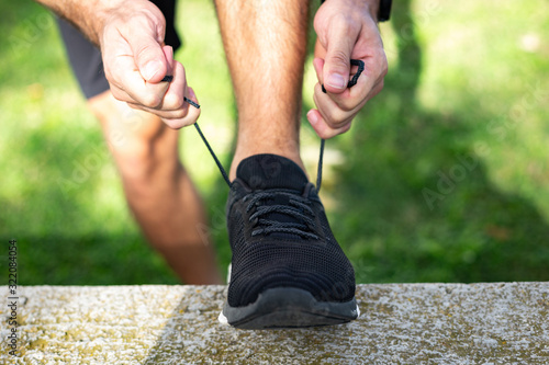 Man tying running shoes getting ready for jogging