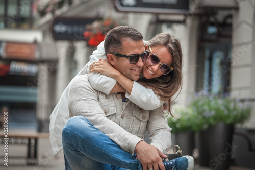 Quadro su tela Loving couple hug sitting on the street.