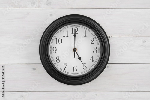 wall round clock black and white with number and clockwise on 5 o'clock straight or five pm am for time out or finish working and after school on vintage white wooden wall or top view table on center