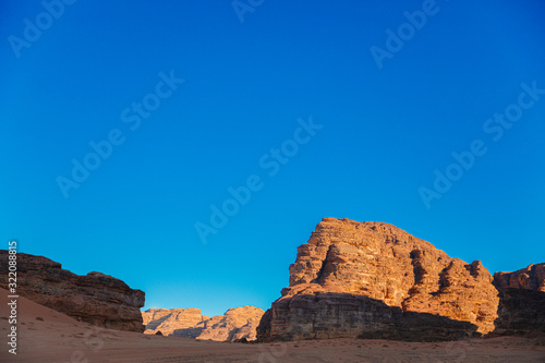 Textured sand mountains of red and orange sand against the blue sky, Jordan, Wadi Rum desert.