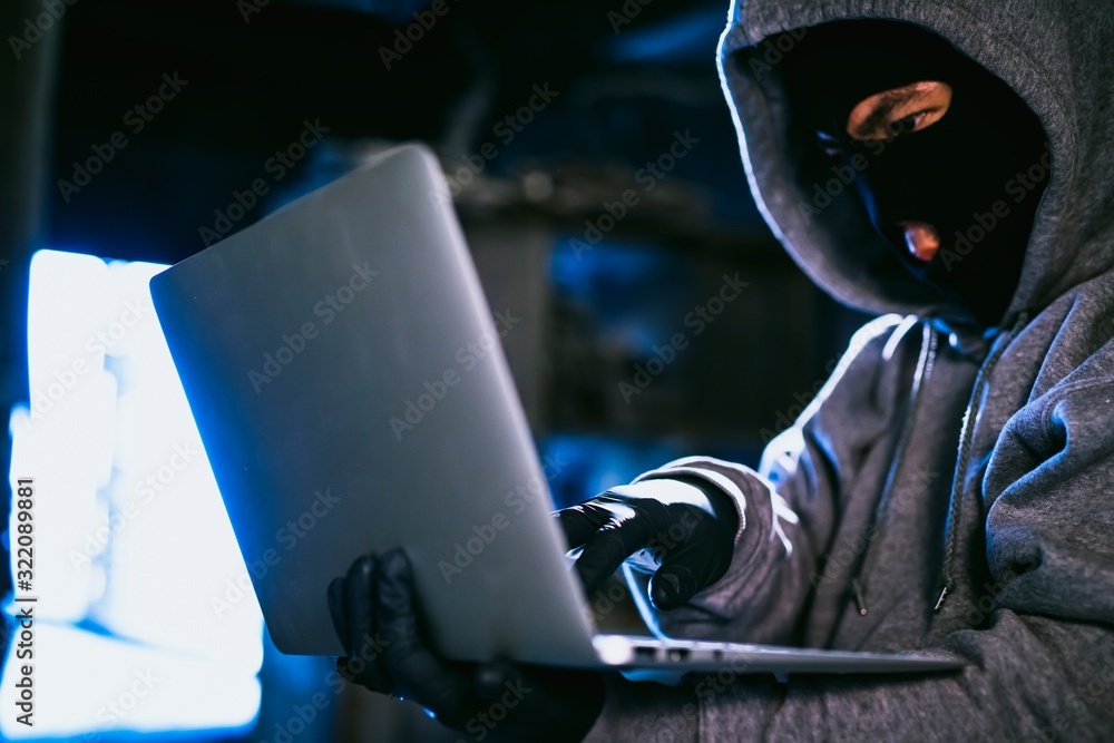hacker in the hood working with laptop hacker in the hood working with laptop