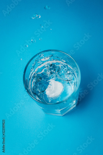 Wallpaper Mural Close up of painkiller tablet in glass of water over blue background Torontodigital.ca