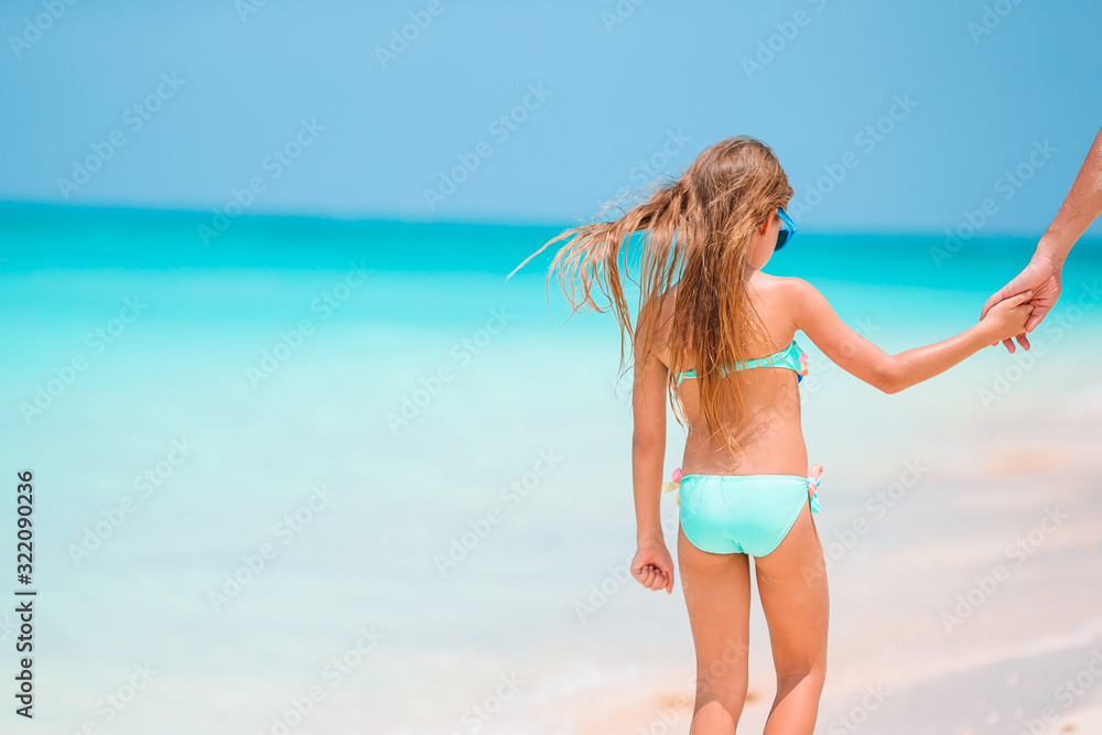 Adorable little girl playing with beach toys on white tropial beach
