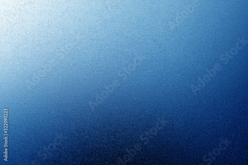 Ground glass texture with light with blur effect in navy blue tone.