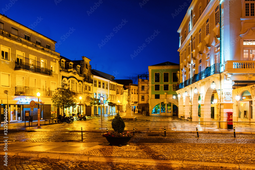 View of city center at night with illuminated buildings and dark blue sky in Aveiro, Portugal