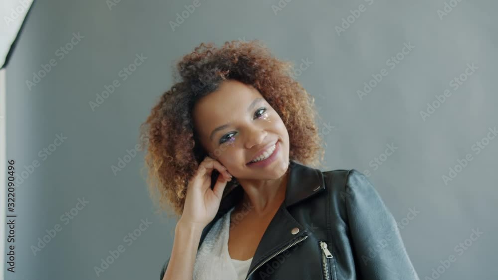 Portrait of pretty young mixed race woman model posing for camera in studio smiling looking at camera. Occupation, modelling and lifestyle concept. Portrait of pretty young mixed race woman model posing for camera in studio smiling looking at camera. Occupation, modelling and lifestyle concept.