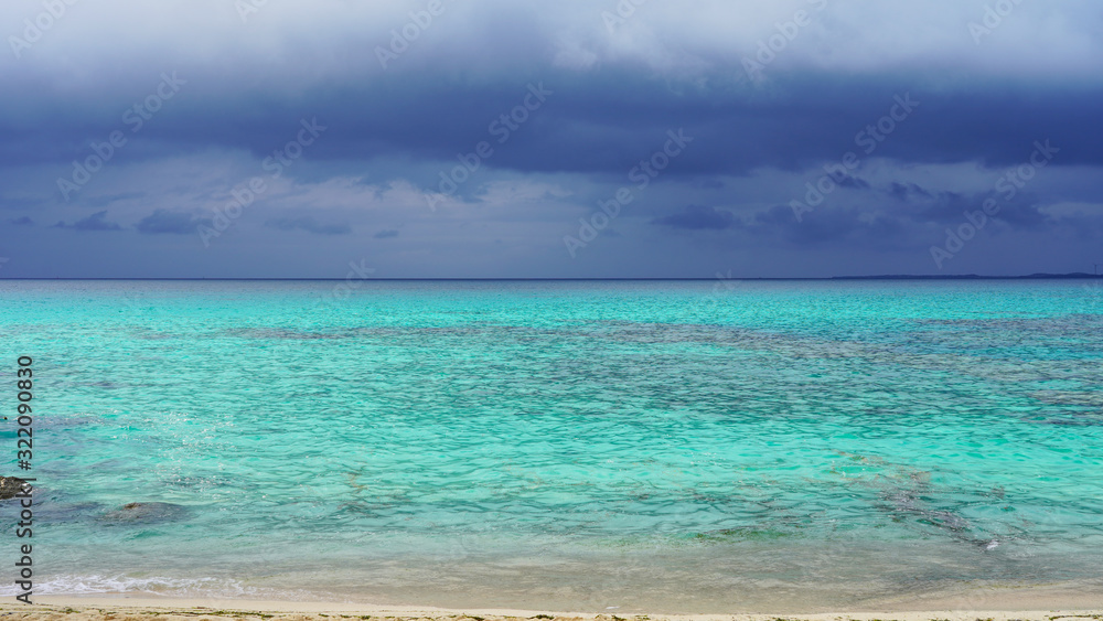 Incredible bright blue turquoise water of the Pacific Ocean off the coast of a tropical island. stormy sky over bright clear sea water