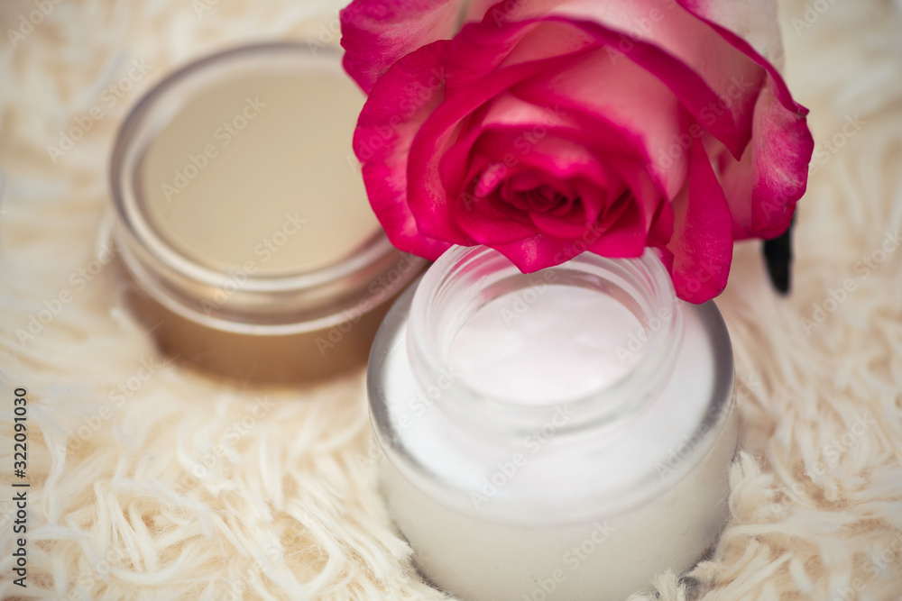 Skincare concept. cream in a glass jar with an open lid and a rose Skincare concept. cream in a glass jar with an open lid and a rose