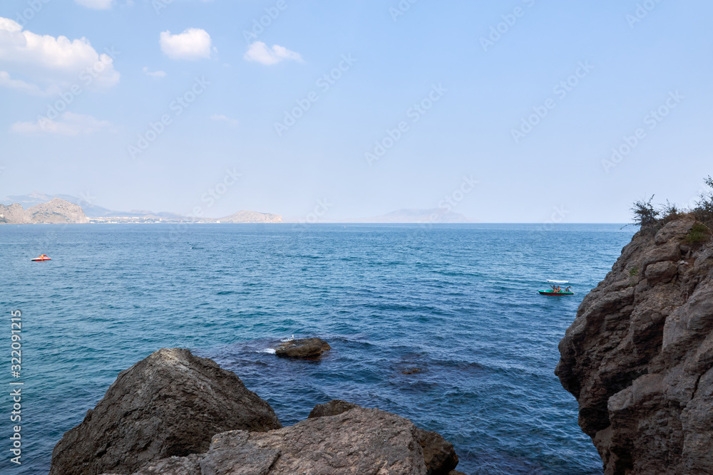 View of the Green Bay in the village of New World, coastal cliffs and a ridge of mountains on the horizon. Black Sea coast, Sudak region, Republic of Crimea
