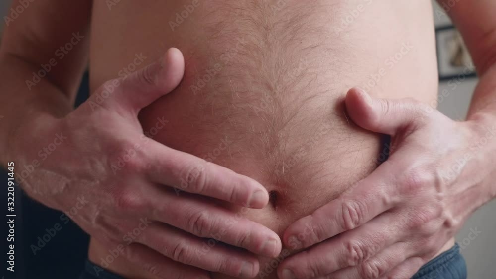 Mature white man inflates his hairy belly, slaps himself with hands, strains it Mature white man inflates his hairy belly, slaps himself with hands, strains it